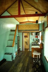 a small kitchen with a table and a staircase in a room at Country Cottage in Papa Bay in Papa Bay Estates