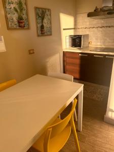 a kitchen with a table and chairs and a microwave at TERRATETTO SUNSET in Capoliveri