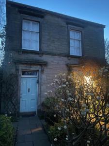 a brick house with a blue door and windows at Large 3 double bedroom period house with parking in Edinburgh
