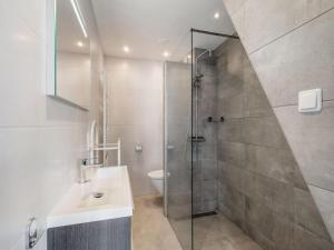 een badkamer met een douche, een wastafel en een toilet bij Appartement De Zeebries Koudekerke in Koudekerke