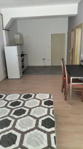 Il comprend un salon avec une table et des chaises ainsi qu'une cuisine. dans l'établissement TC Vest Residence, à Leţcani