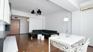 コンスタンツァにあるDeluxe Dionysos Apartmentのリビングルーム(ソファ、テーブル、椅子付)
