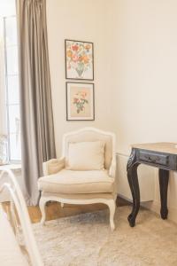 a white chair in a room with a table and a desk at Villa Platani Luxury Suite in Cianciana