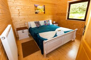 a small bedroom with a bed in a log cabin at 5 Sterne Ferienhaus Tommy mit Kamin, Seeblick und großer Terrasse in Rieden