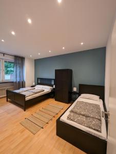 2 łóżka w dużym pokoju z drewnianą podłogą w obiekcie cosy 2 bedroom apartment 75m2 w mieście Mönchengladbach