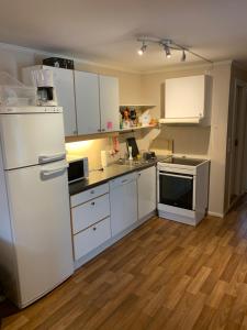 a kitchen with white appliances and a wooden floor at Two bedroom apartement in Sogndal