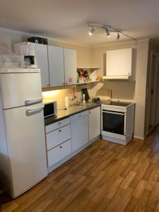a kitchen with white appliances and a wooden floor at Two bedroom apartement in Sogndal +31 photos