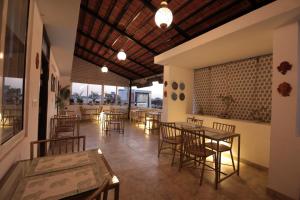 a restaurant with tables and chairs and windows at Jai Villa - A Boutique Hotel in Jaipur