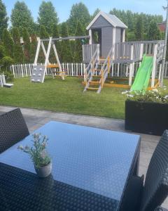 una mesa y sillas en un patio trasero con parque infantil en Hotel Exclusive President en Morančani