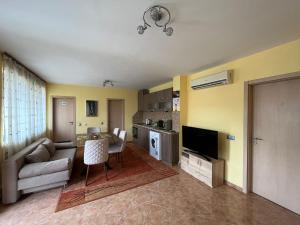 a living room with a couch and a table and a kitchen at Apartment Sanik in Varna City