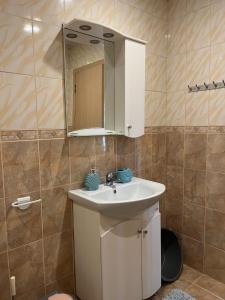 a bathroom with a white sink and a mirror at Apartment Sanik in Varna City