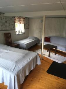 a bedroom with two beds and a table in it at Charmig Ölandsgård in Köpingsvik