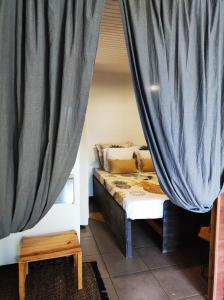 ein Schlafzimmer mit einem Bett und einem Vorhang in der Unterkunft Le Cacaoyer in La Trinité