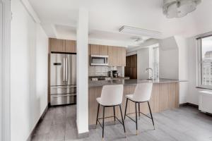 a kitchen with two white chairs and a counter at UES 3br w balcony doorman nr Central Park NYC-1192 in New York