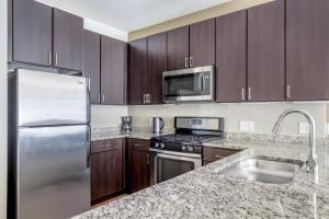 a kitchen with stainless steel appliances and wooden cabinets at Somerville 1br w wd gym roof nr Assembly T BOS-840 in Somerville
