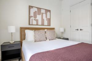 a bedroom with a large white bed with two lamps at Somerville 1br w wd gym roof nr Assembly T BOS-840 in Somerville