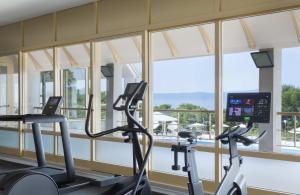 a gym with two cardio machines and a large window at Bluesun Holiday Village Afrodita in Tučepi