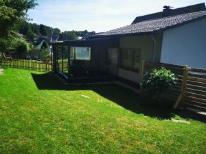 a small house with a fence next to a yard at Ferienwohnung Waldbröl in Waldbröl