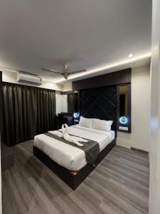 a bedroom with a large bed with a black headboard at Hotel Classio Andheri - Near DN Nagar Metro Station in Mumbai