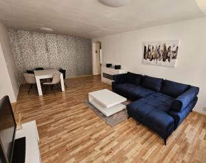 ein Wohnzimmer mit einem blauen Sofa und einem Tisch in der Unterkunft Penzión TIME in Prešov
