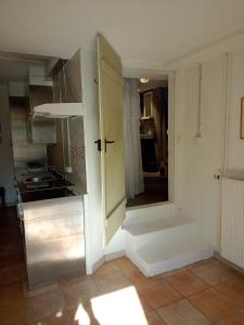 uma cozinha com uma porta aberta para uma cozinha com um fogão em Casa Nemea em Neuenegg