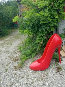 um sapato de salto alto vermelho sentado ao lado de um arbusto em Casa Nemea em Neuenegg