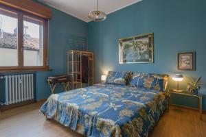 a blue bedroom with a bed and a window at Maison D'Or in Trieste