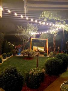 a garden with a bench in the middle of a yard with lights at NIKI HOUSE in Bansko