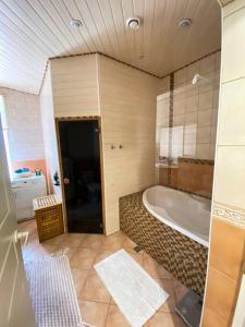 ein Bad mit einer Badewanne in einem Zimmer mit in der Unterkunft House in Bulduri/Jūrmala nearby the beach(7min) in Jūrmala