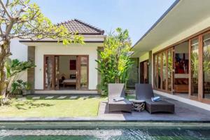 a villa with a swimming pool and a house at Villa Vidya Managed by Manara in Seminyak