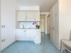 a kitchen with white cabinets and a sink at Green Village Resort in Villasimius