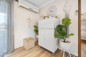 una habitación con un armario blanco y una maceta en INVERLOCH Beach House, en Inverloch