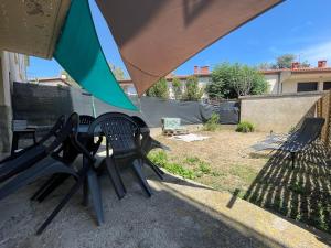 - une table et des chaises sous un parasol sur la terrasse dans l'établissement LG RITE Appartement avec jardin, à Prades