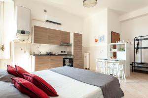 a bedroom with a large bed with red pillows at Appartamento Baia del Re - Navigli in Milan