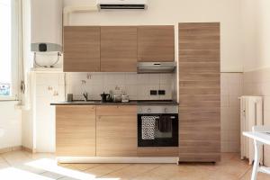 a kitchen with wooden cabinets and a stove at Appartamento Baia del Re - Navigli in Milan