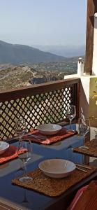 a table with plates and wine glasses on a balcony at Carataunas House Alpujarra in Carataunas