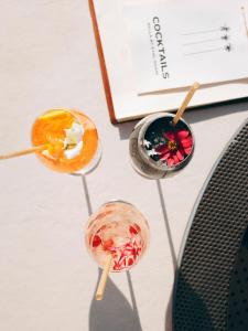 two cocktails sitting on a table next to a book at Hôtel & Spa Belle Plage in Cannes