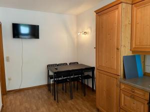 a kitchen with a table with chairs and a television on the wall at Cozy Apartment in Oberhausen in Oberhausen