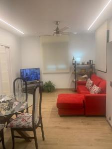 a living room with a red couch and a table at Casa Rural 3 en un fantástico legado in Alfacar
