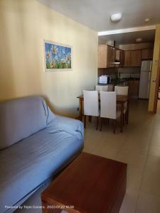 a living room with a couch and a dining room at Apartamento Primera Línea de Playa Isla Canela in Isla Canela