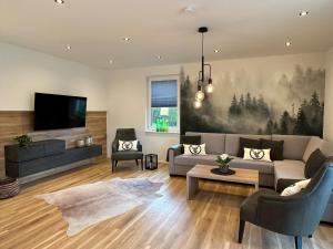ein Wohnzimmer mit einem Sofa und einem TV in der Unterkunft Ferienhaus Waldschatz Baiersbronn in Baiersbronn