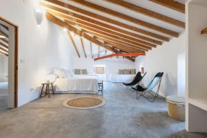 a white room with a bed and a table and chairs at El Convento de Biniamar in El Port de la Selva