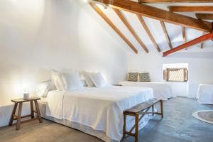 a white bedroom with a large bed and wooden ceilings at El Convento de Biniamar in Selva +37 photos