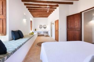 a bedroom with a white bed and a couch at El Convento de Biniamar in El Port de la Selva