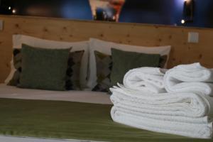 een stapel handdoeken bovenop een bed bij Nazaré Sweet Dreams in Nazaré