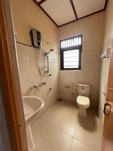 ein Bad mit einem Waschbecken, einem WC und einer Dusche in der Unterkunft The Cinnamon Villa Kandy in Kandy