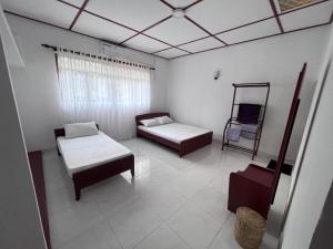 a room with two beds and a chair at The Cinnamon Villa Kandy in Kandy