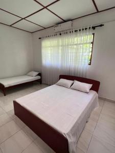 um quarto com uma cama grande e uma janela em The Cinnamon Villa Kandy em Kandy