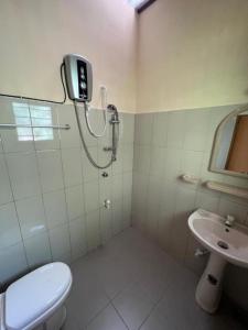 uma casa de banho com um chuveiro, um WC e um lavatório. em The Cinnamon Villa Kandy em Kandy