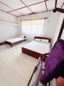 um quarto com duas camas e uma cadeira em The Cinnamon Villa Kandy em Kandy